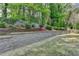 Scenic backyard featuring tiered landscaping with retaining wall, lush trees, and a wooden fence at 335 Wyehwood Ct, Alpharetta, GA 30022