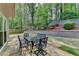 Landscaped backyard featuring patio with outdoor furniture, retaining wall, and lush greenery at 335 Wyehwood Ct, Alpharetta, GA 30022