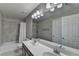 Bathroom featuring double sink vanity with dark wood cabinets and a shower-tub combo with tiled walls at 335 Wyehwood Ct, Alpharetta, GA 30022