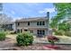 Backyard with patio, featuring two story home, landscaping with a retaining wall and mature bushes at 335 Wyehwood Ct, Alpharetta, GA 30022