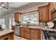 Well-lit kitchen with wood cabinets, modern appliances, tile backsplash, and backyard view at 335 Wyehwood Ct, Alpharetta, GA 30022