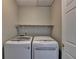 Laundry room with full size white washer and dryer, with storage shelf above, and neutral paint at 335 Wyehwood Ct, Alpharetta, GA 30022