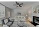 Comfortable living room with fireplace, ceiling fan, and view into an adjacent room at 335 Wyehwood Ct, Alpharetta, GA 30022