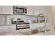 Kitchen with an undermount sink, stainless steel oven, and light gray backsplash at 505 Altamaha Court, Locust Grove, GA 30248