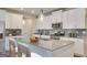This kitchen features white cabinets, stainless appliances, island bar, and granite countertops at 505 Altamaha Court, Locust Grove, GA 30248