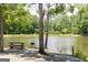 Relaxing lake view featuring a picnic table and grill surrounded by trees and serene water at 505 Altamaha Court, Locust Grove, GA 30248