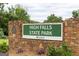 Stone sign at High Falls State Park with green lettering and landscaping in front at 505 Altamaha Court, Locust Grove, GA 30248
