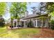 Enjoy outdoor living in this backyard with a stone patio, pergola, green lawn, and mature landscaping at 1442 Valley Glen Way, Dunwoody, GA 30338