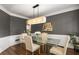 Contemporary dining room featuring a glass table, elegant chairs, modern lighting, and wainscoting details at 1442 Valley Glen Way, Dunwoody, GA 30338