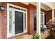 Inviting front porch featuring a black front door, brick accents, and a cozy seating area with a welcome mat at 1442 Valley Glen Way, Dunwoody, GA 30338