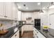 Well-appointed kitchen featuring black countertops, white cabinets, and stainless steel appliances at 1442 Valley Glen Way, Dunwoody, GA 30338