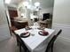 Dining room with a view of the kitchen and living room; features a table set for four at 2162 Oakland Grove Pl, Lawrenceville, GA 30044