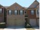 Townhome exterior with brick facade, two-car garage, and neatly manicured bushes at 2162 Oakland Grove Pl, Lawrenceville, GA 30044