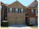 Townhome exterior boasts a brick facade, two-car garage, and well-maintained landscaping at 2162 Oakland Grove Pl, Lawrenceville, GA 30044