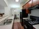 Kitchen with dark cabinets, black appliances, and a view of the dining area at 2162 Oakland Grove Pl, Lawrenceville, GA 30044
