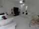Living room with a fireplace, white sofas with plum pillows, and a dark TV at 2162 Oakland Grove Pl, Lawrenceville, GA 30044