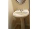 Classic powder room with pedestal sink, chrome faucet, and decorative mirror at 2162 Oakland Grove Pl, Lawrenceville, GA 30044