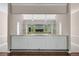 Well lit bar area with glass shelving, mirrored backsplash, white cabinetry, and hardwood floors at 2320 Copper Trail Ln, Buford, GA 30519
