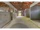 Interior of a barn with concrete floor, stalls, open rafters, and a back exit at 2320 Copper Trail Ln, Buford, GA 30519