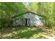 Exterior of a rustic barn with red doors surrounded by trees and foliage at 2320 Copper Trail Ln, Buford, GA 30519