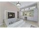 Luxurious bathroom featuring a jacuzzi tub, a fireplace, and a vanity area with ample storage at 2320 Copper Trail Ln, Buford, GA 30519