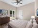 Bright bedroom featuring wood-look flooring, neutral paint, and a ceiling fan, with natural light streaming through the window at 2320 Copper Trail Ln, Buford, GA 30519
