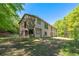 Two-story home with neutral siding and dark trim, nestled amongst trees at 2320 Copper Trail Ln, Buford, GA 30519