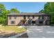 Two-story house with black-framed windows, tan siding, and a concrete driveway under a clear blue sky at 2320 Copper Trail Ln, Buford, GA 30519
