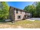 Two-story house with black-framed windows, tan siding, and lush green surroundings on a sunny day at 2320 Copper Trail Ln, Buford, GA 30519