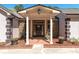 Inviting front porch with stone pillars, manicured planters, and a brick walkway leading to the front door at 2320 Copper Trail Ln, Buford, GA 30519