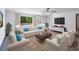 Bright living room featuring hardwood floors, neutral furniture, a ceiling fan, and a view of lush greenery outside at 2320 Copper Trail Ln, Buford, GA 30519