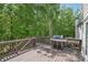 Outdoor deck with a grill, surrounded by lush trees and natural beauty at 553 Augusta Dr, Canton, GA 30115