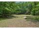 Expansive backyard featuring mature trees, a small bridge, and lush greenery, offering a serene outdoor retreat at 553 Augusta Dr, Canton, GA 30115