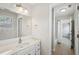 Bright bathroom features a large mirror, white vanity, and a door with access to the shower and toilet at 553 Augusta Dr, Canton, GA 30115