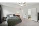 Well-lit bedroom boasts en-suite bath, a ceiling fan, and neutral walls and carpet at 553 Augusta Dr, Canton, GA 30115