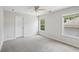 Bright bedroom features neutral carpet, ceiling fan, and natural light from two windows at 553 Augusta Dr, Canton, GA 30115