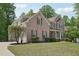 Brick exterior home with a manicured lawn and a curved driveway leading to the side-entry garage at 553 Augusta Dr, Canton, GA 30115