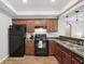 Well-lit kitchen featuring wood cabinets, modern black appliances, and stylish countertops at 553 Augusta Dr, Canton, GA 30115