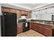 Well-lit kitchen featuring wood cabinets, modern black appliances, and stylish countertops at 553 Augusta Dr, Canton, GA 30115