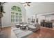 Open-concept living room with large windows, hardwood floors, and flows into the kitchen and dining area at 553 Augusta Dr, Canton, GA 30115