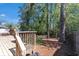 A wooden backyard deck features built in seating and a gas grill, with access to a spacious, wooded yard at 705 Stewart Nw Cir, Marietta, GA 30064