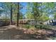 Wide backyard showcasing shade trees and lawn space, featuring a patio and seating area at 705 Stewart Nw Cir, Marietta, GA 30064