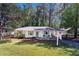 Inviting ranch-style home with well-manicured lawn and charming front porch seating area at 705 Stewart Nw Cir, Marietta, GA 30064