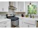Modern kitchen with white cabinets, stainless steel appliances, and stylish tile backsplash at 705 Stewart Nw Cir, Marietta, GA 30064