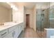 Bathroom showcases a glass shower, double vanity with stone countertops, and natural light at 7505 Woolf Way, Cumming, GA 30028