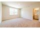 Carpeted bedroom showcasing two windows and an attached bathroom with vanity, offering natural light and convenience at 7505 Woolf Way, Cumming, GA 30028