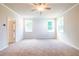 Bright bedroom features neutral carpet, ceiling fan, and natural light from two windows at 7505 Woolf Way, Cumming, GA 30028