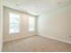 Bedroom with neutral carpet, two windows, and ample natural light at 7505 Woolf Way, Cumming, GA 30028