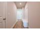 Hallway with wood floors, a built-in bench, and access to other rooms in the house at 7505 Woolf Way, Cumming, GA 30028