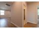 Spacious hallway with hardwood floors and neutral walls, with a bathroom entryway visible at 7505 Woolf Way, Cumming, GA 30028